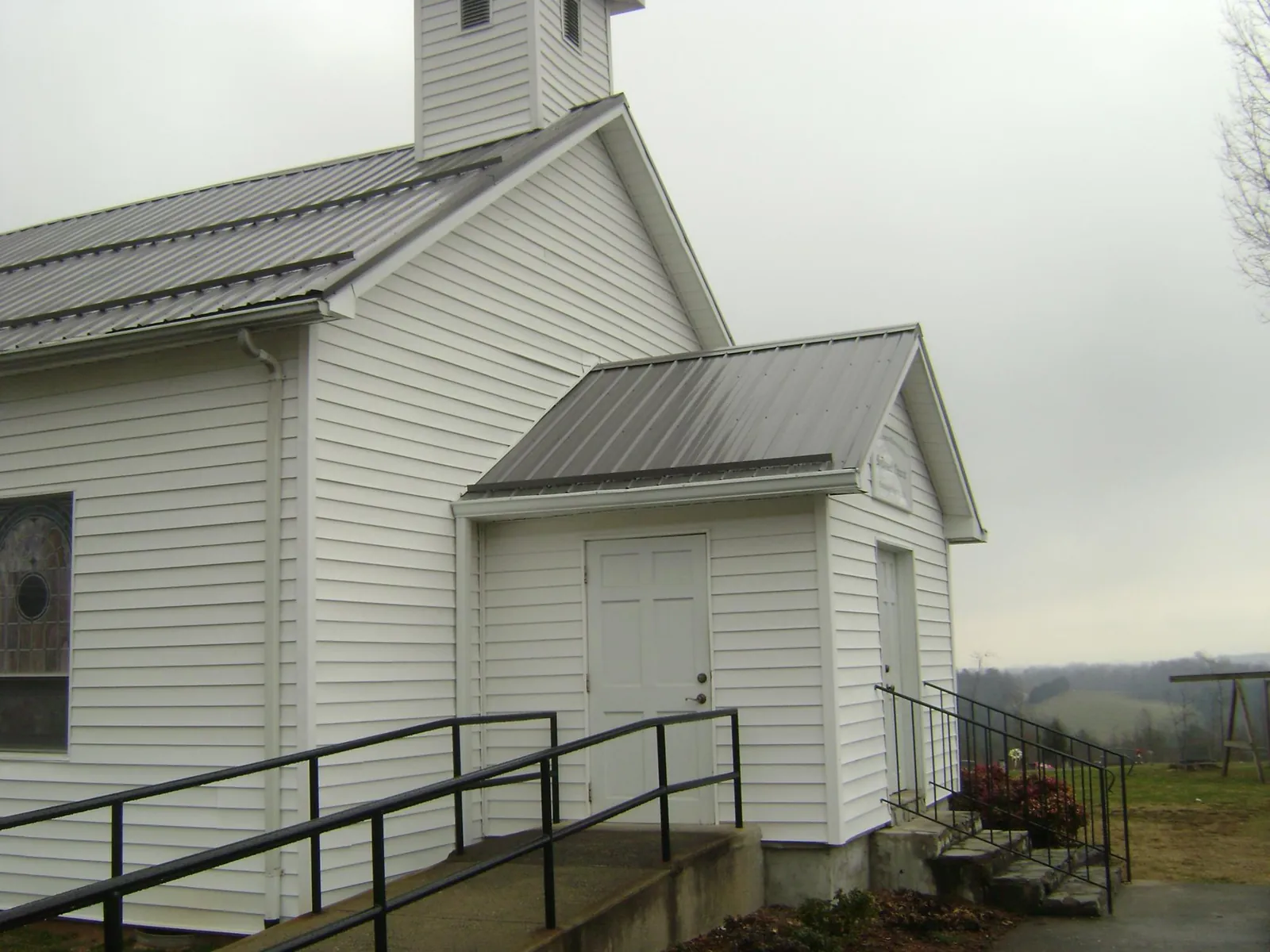 Gray metal roof on a white clapboard church with a steeple in Lincoln